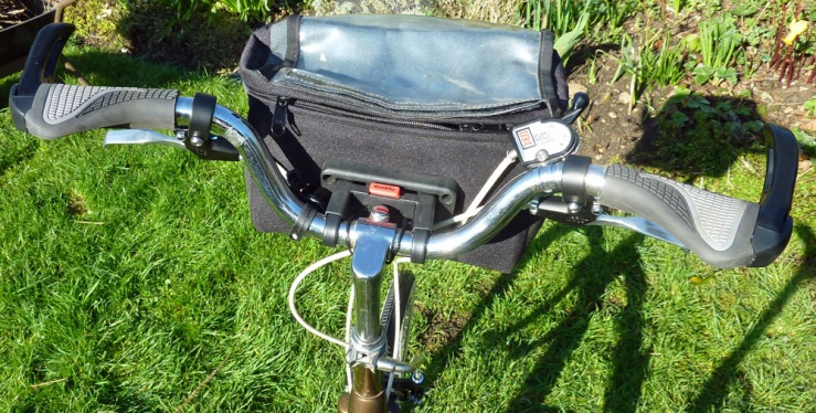A rider's-eye view of the handlebar cluster, showing the Klickfix bracket, the Sturmey-Archer 3-speed trigger and a bell, tcuked away by the bag bracket. This set-up enables the bike to be stood upside for maintenance, supported well by the handlebar grip extensions and saddle.